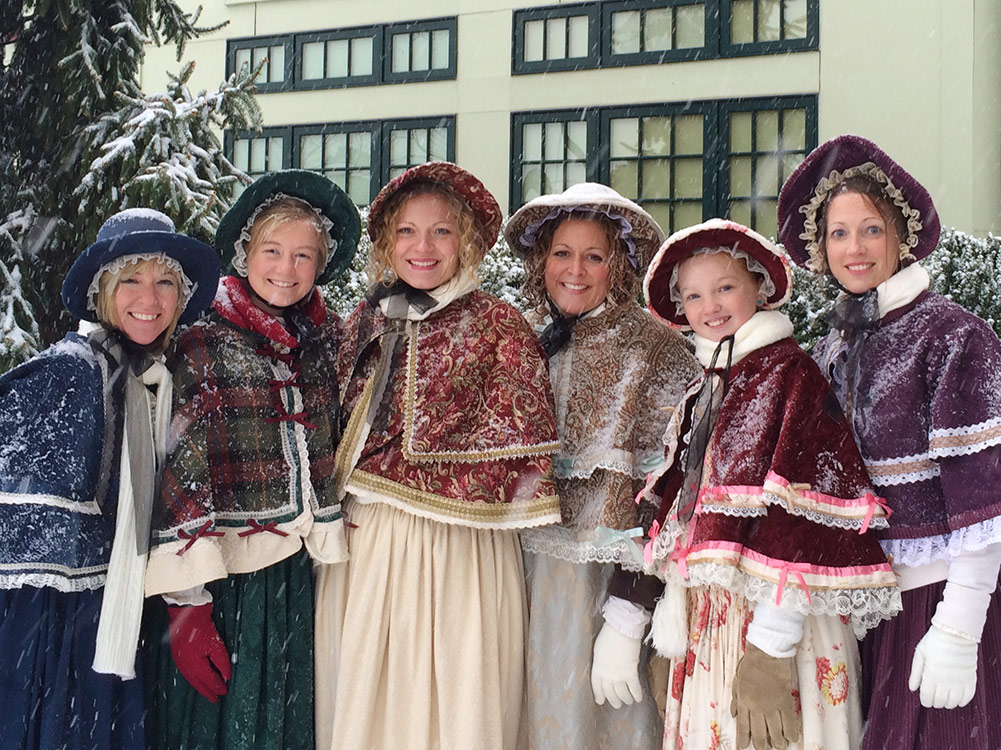 Victorian Christmas carolers standing in the snow