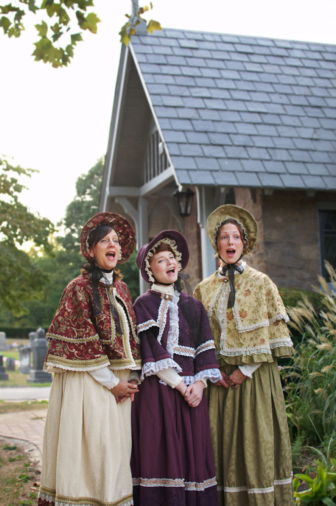 Victorian Christmas Carolers singing in front of historic building